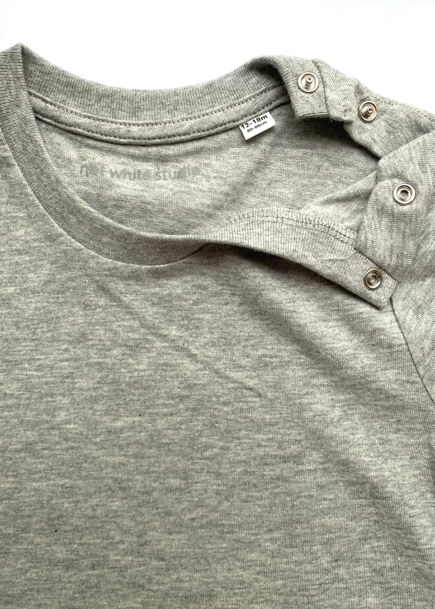 Grey Melange. Nachhaltiges CELEBRATE YOUR MINI TSHIRT aus 100% Bio-Baumwolle. Mit Druckknopf für leichtes An- und Ausziehen. Personalisierbar mit Flockbuchstaben (Öko-Tex-Standard 100) auf dem Rücken. Pflegehinweise beachten für lange Freude am Shirt. Individuelle Fertigung, Lieferzeit 3-10 Tage.