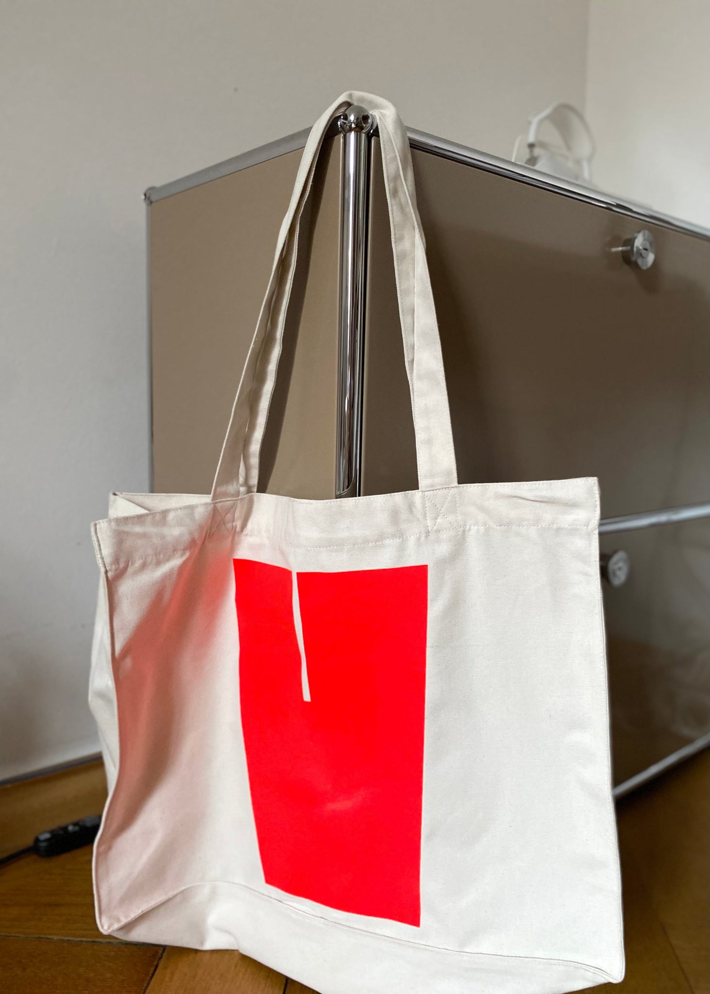 "Personalisierbare XL Shopper-Tasche aus 80% recycelter Baumwolle und 20% recyceltem Polyester. Auf der Vorderseite befindet sich ein individueller Flockdruck mit einem Buchstaben, der den Öko-Tex-Standard 100 erfüllt. Die nachhaltige Tasche von not white studio vereint Stil und Umweltbewusstsein. 